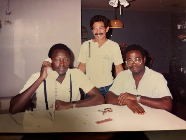 Abel holding a telephone receiver with Kofi and Leonora's brother in Miami in 1987