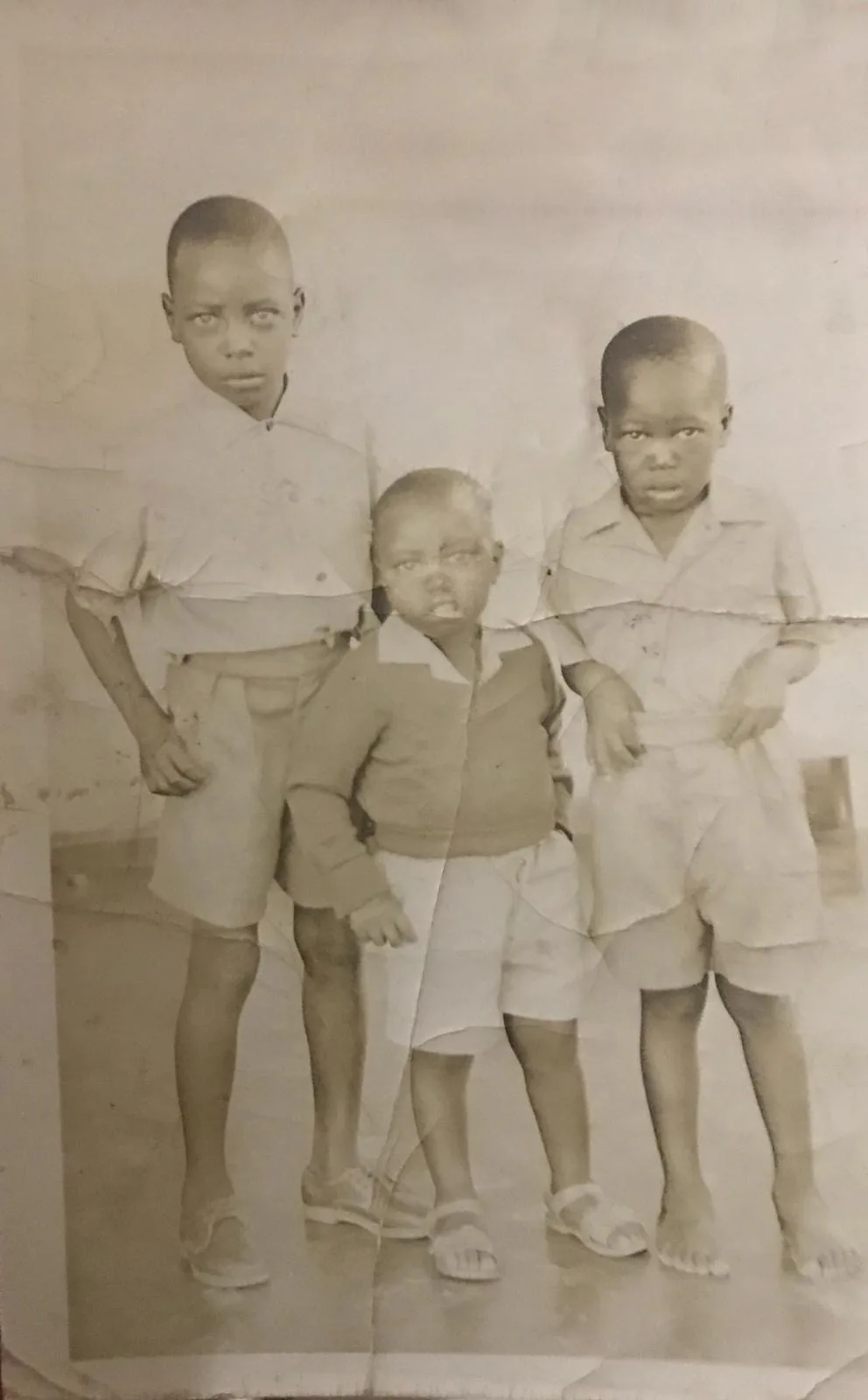 Abel, approximately five years old, flanked by his two brothers in Zambia