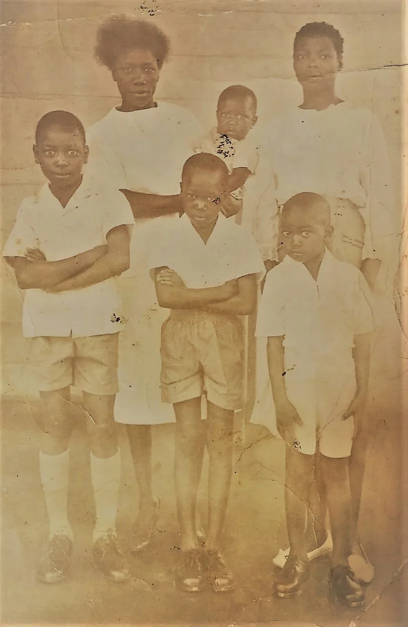 Abel, approximately six years old, flanked by his two brothers in Zambia